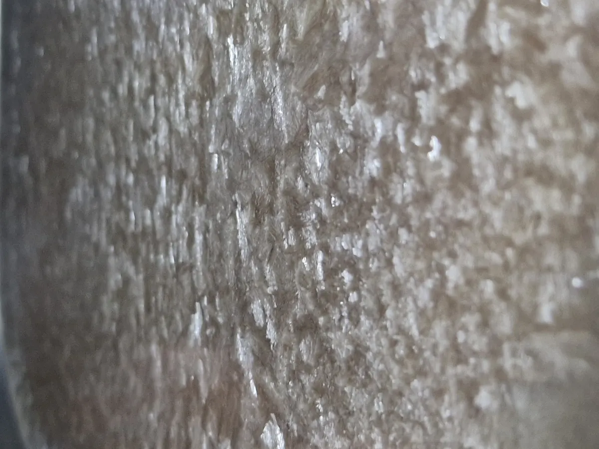 Extreme close-up of the frozen beef broth surface part-way through the cycle, showing ice crystals and a porous matrix